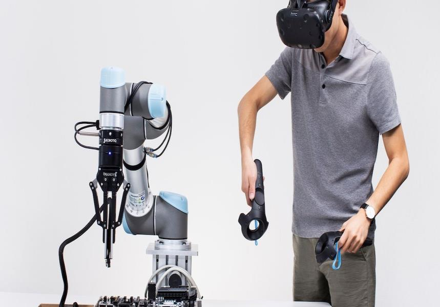 Operator with VR controllers working alongside a robotic arm